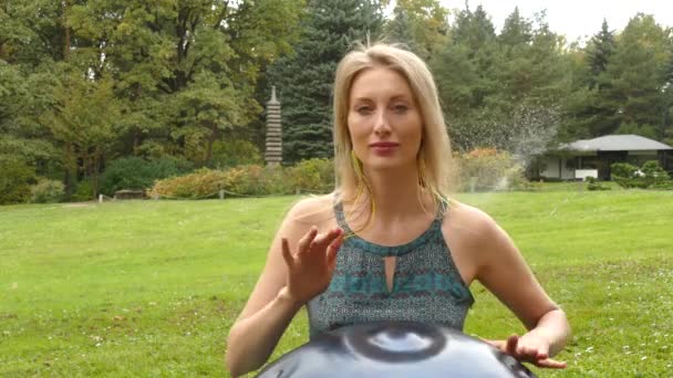 Charmante blonde speelt een hang op het gazon — Stockvideo