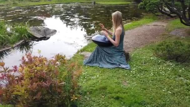 Mooie jonge vrouw speelt een hang in het herfst Park — Stockvideo