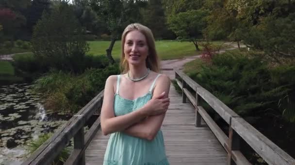 Jeune femme blonde caucasienne marche dans le parc . — Video