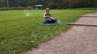 Güzel genç kadın sonbahar parkta bir asmak çalış