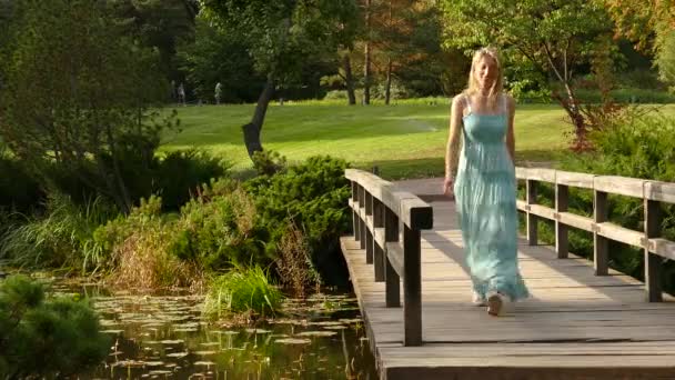 若い白人ブロンドの女性は公園で歩く. — ストック動画