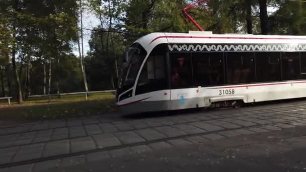 Moderno tranvía de Moscú paseos a través del parque de la ciudad . — Vídeos de Stock