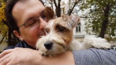 Beyaz köpek yavrusu ve yetişkin bir adam açık havada