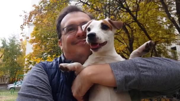 Bílé štěně s dospělým mužem venku — Stock video