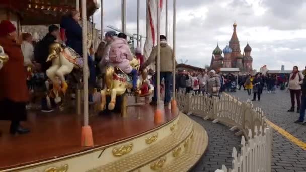 Lidé na kolotoči na pozadí Kremlu — Stock video