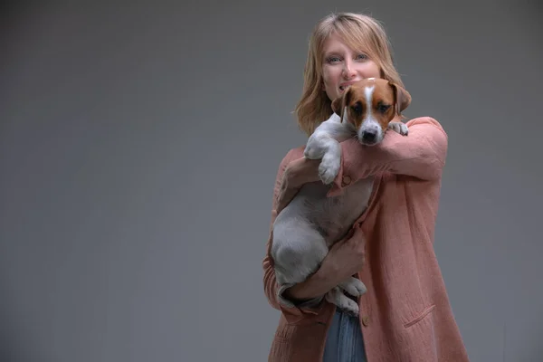 Cachorro mira a la cámara sentado de las manos de su dueño — Foto de Stock