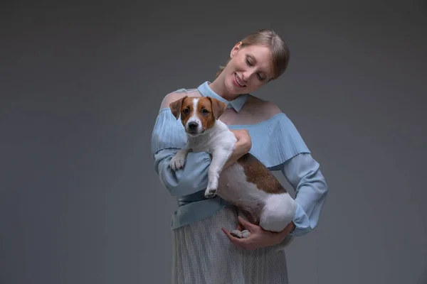 Klasik Elbiseli Sarışın Kadını Jack Russell Köpeğini Tutuyor — Stok fotoğraf