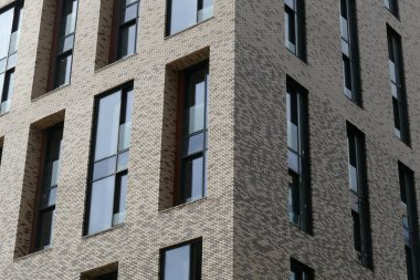 Çok katlı bir apartmanın dış cephesi, pencereleri ve balkonları..