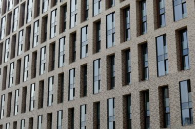 Çok katlı bir apartmanın dış cephesi, pencereleri ve balkonları..
