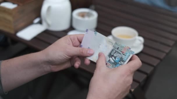 Man telt Koeweitse dinar te betalen voor koffie in een straat cafe — Stockvideo