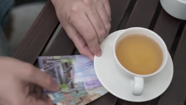 Чоловік клав кувейтські динари, щоб заплатити за каву в кафе. — стокове відео