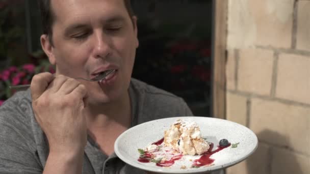 Человек ест безе — стоковое видео