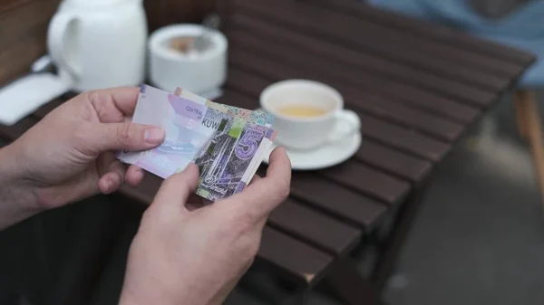 Muž počítá kuvajtské dináry platit za kávu v pouliční kavárně — Stock fotografie