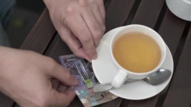 Bir sokak kafesinde faturalara dokunmak beni geriyor.