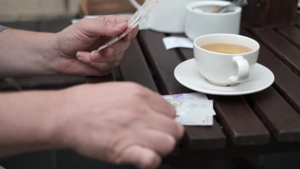 Man zet Koeweitse dinar om koffie te betalen in een café op straat — Stockvideo