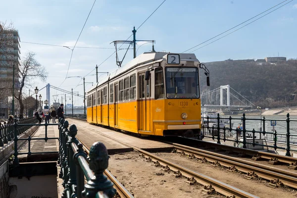 ブダペスト,ハンガリー, 2018年3月22日:曇りの空で初冬の黄色いトラム。路面電車2号線はナショナル・ジオグラフィック社が選定したヨーロッパの最高路線として有名です。 — ストック写真