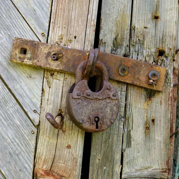 Una vieja cerradura en la puerta. cerrar la puerta de una antigua granja. verdadero estilo de pueblo — Foto de Stock