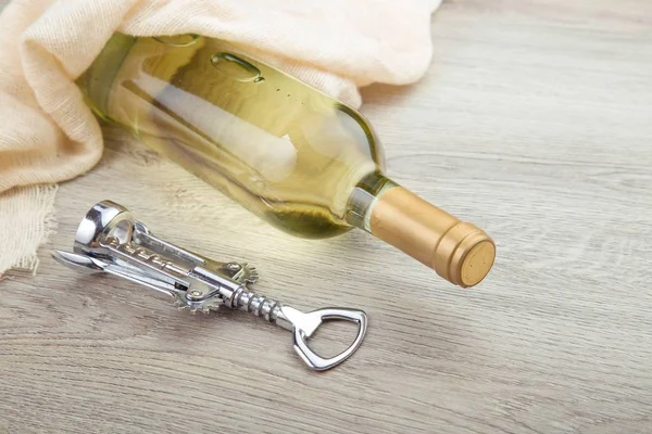 Fles wijn met corkscrew op houten achtergrond — Stockfoto