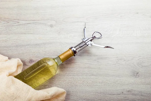 Fles wijn met corkscrew op houten achtergrond — Stockfoto