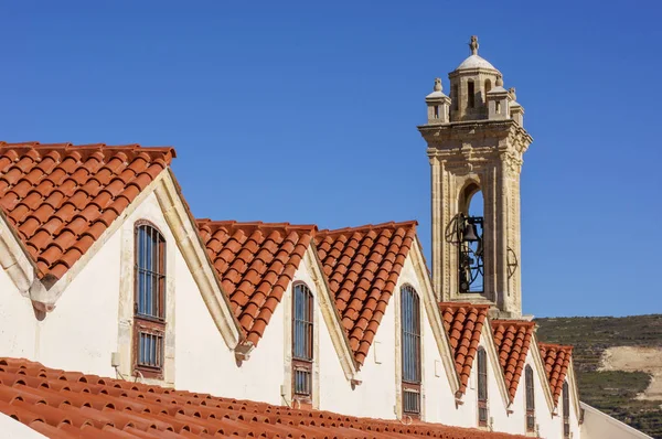 Hög vinkel syn på orange kakel och byggnad tak i gamla stan med toppen av dess landmark klocktorn som är klart synlig — Stockfoto