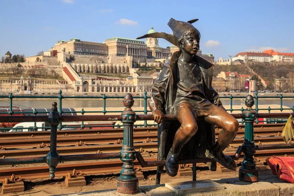 Budapest, Ungern, mars 22 2018: Staty av en sittande barn med en hatt nära spårvagn järnväg på stranden av Donau — Stockfoto