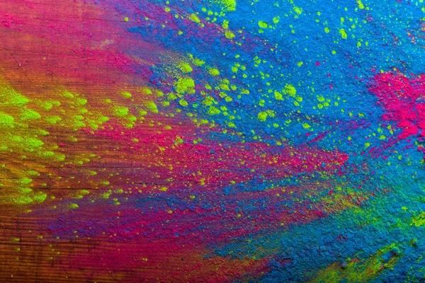 Abstrakt färgglada glad Holi bakgrund. Färg pulserande pulver på trä. Damm färgade stänk textur. Lägenheten låg holi måla dekoration — Stockfoto