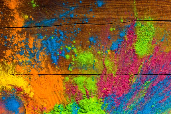 Abstrakte bunte fröhliche Holi Hintergrund. Farbe lebendigen Puder auf Holz. staubfarbene Spritztextur. flach liegend Holi Farbe Dekoration — Stockfoto