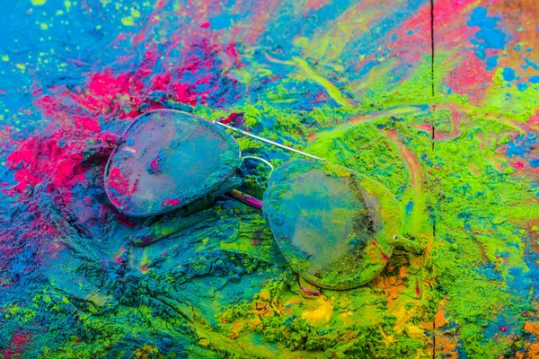 Holi color powder on sunglasses. Organic Gulal colours on eyeglasses for Holi festival, Hindu tradition festive — Stock Photo, Image