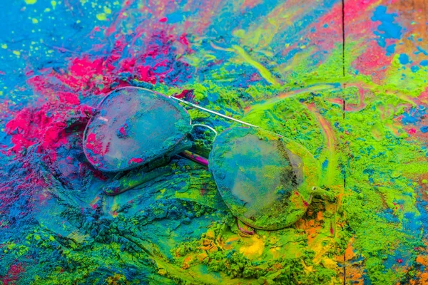 Holi poudre de couleur sur les lunettes de soleil. Couleurs de Gulal bio sur lunettes pour le festival Holi, tradition hindoue festive — Photo