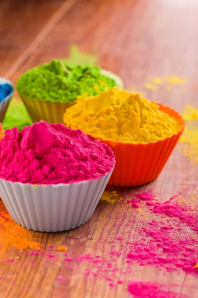 Holi färg pulver. Organiska Gulal färger i skål för Holi festival, hinduiska traditionen festlig. Blå, rosa, magenta, orange, gul holi torrt målar på trä skrivbord bakgrund — Stockfoto
