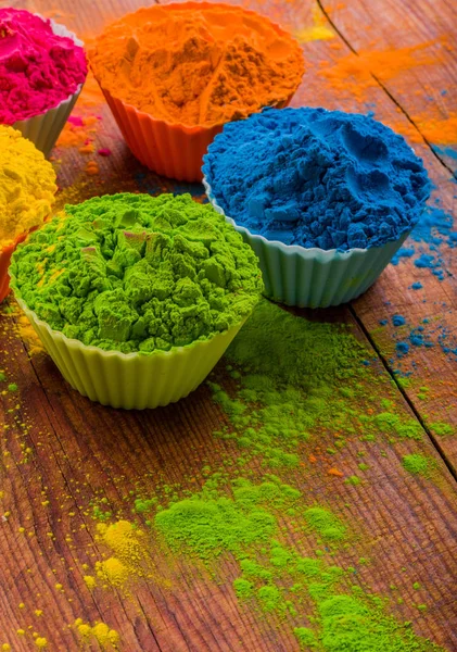 Holi color powder. Organic Gulal colours in bowl for Holi festival, Hindu tradition festive. Blue, pink, magenta, orange, yellow holi dry paints on wood desk background — Stock Photo, Image