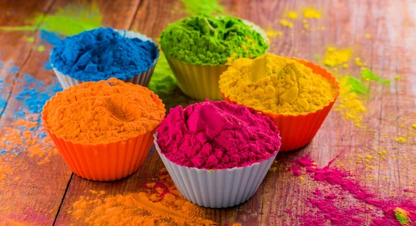 Vivid colorful Holi dye powder in cups. Shallow depth of field. — Stock Photo, Image