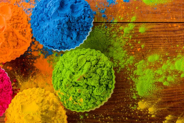 Draufsicht auf buntes traditionelles Holi-Pulver in Schalen auf Holz — Stockfoto