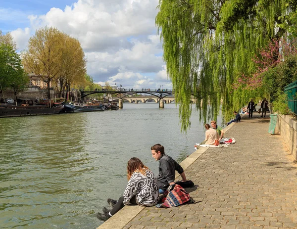 Paris, Fransa, 1 Nisan 2017: İnsanlar Seine Nehri kıyısında güneş ışığının tadını çıkarıyor. 2m nüfusu ile Paris Fransa'nın başkenti ve en kalabalık şehridir. — Stok fotoğraf