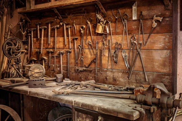 Banco de trabajo completo con pared de herramientas en un taller. Aspecto vintage — Foto de Stock