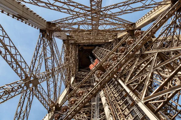 法国巴黎，2017年3月30日：法国巴黎埃菲尔铁塔内。欣赏埃菲尔铁塔内部。大轴测量建筑。早上的特写镜头蓝天，阳光明媚 — 图库照片