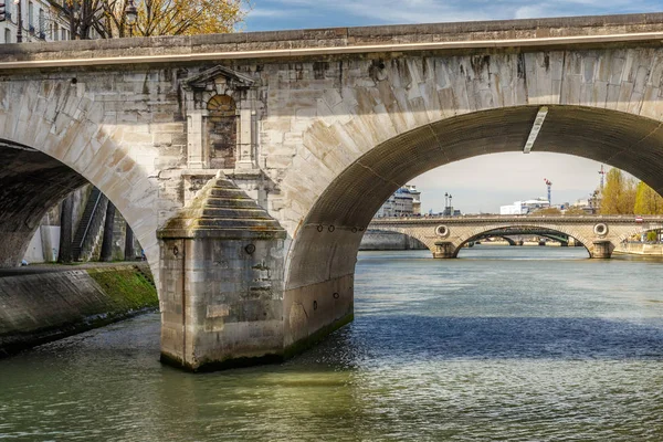 Paříž, Francie, 30. března 2017: Paris Bridge. Mosty z Paříže přes řeku Seine, za krásného oblačného dne. Nejméně 37 mostů pokrývá řeku Seine, řeka oddělující levý a pravý břeh Paříže — Stock fotografie