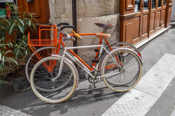 Paris, France, April 1, 2017: Old style bicycle in front of the Paris restaurant. Typical French street in Montmartre district with small houses are located cafes, restaurants and art galleries — Stock Photo, Image
