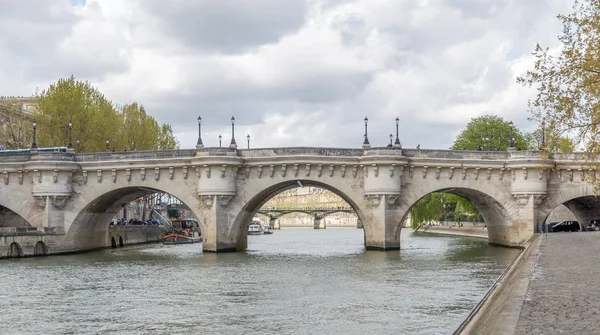 Paříž, Francie, 1. dubna 2017: Paris Bridge. Mosty z Paříže přes řeku Seine, za krásného oblačného dne. Nejméně 37 mostů pokrývá řeku Seine, řeka oddělující levý a pravý břeh Paříže — Stock fotografie