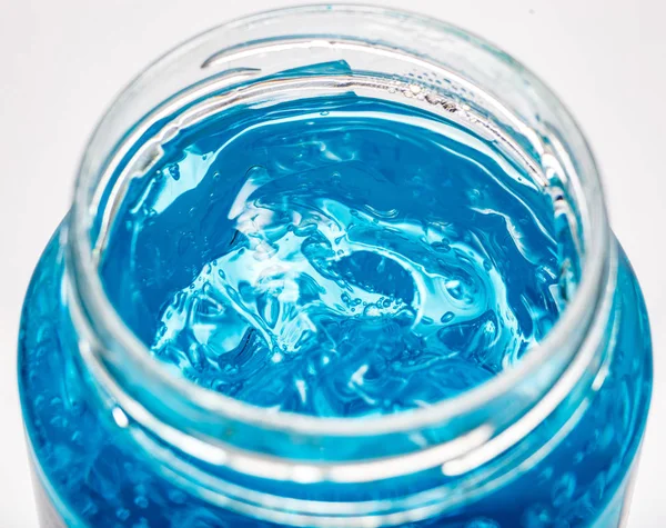 Recipiente de gel azul isolado no fundo branco da vista superior. Gel transparente com bolhas close-up — Fotografia de Stock
