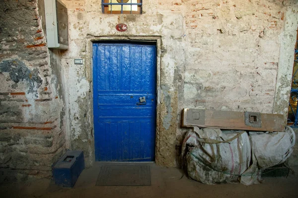 Старі і вдягнені сині дерев'яні двері з залізною ручкою. Рустик синіх дверей вхід в старий кам'яний будинок — стокове фото