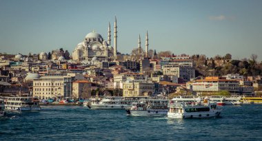 Istanbul, Turkey, 22 March 2019: Touristic sightseeing ships in Golden Horn bay of Istanbul and view on Suleymaniye mosque from the Golden Horn metro Bridge clipart