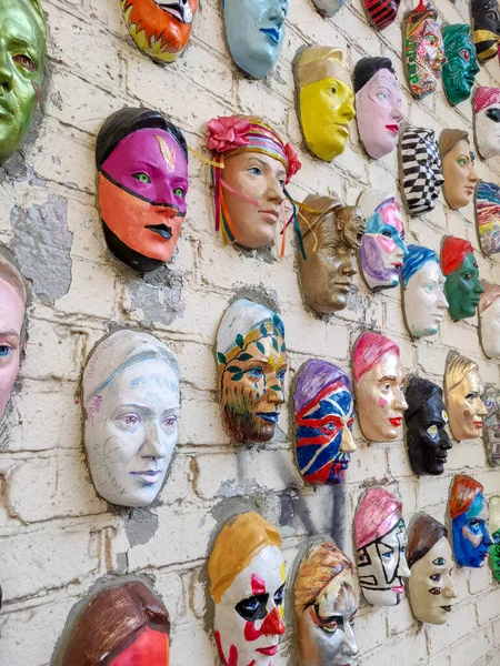 Moscou, Rússia, 21 de outubro de 2019: Escultura colorida de faces cerâmicas pintadas na parede de tijolos como objeto de arte moderna. Cem caras de Marat Nabi. Parede de tijolos com elemento decorativo — Fotografia de Stock