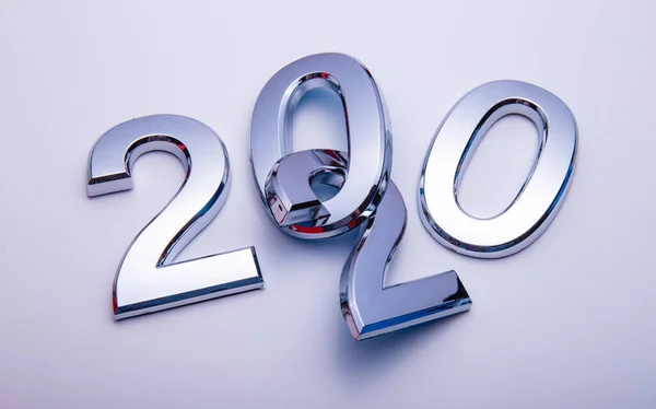 Gott nytt år 2020. Symbol från nummer 2020 på ljus bakgrund. Silverbokstäver i form av siffror 2020. — Stockfoto