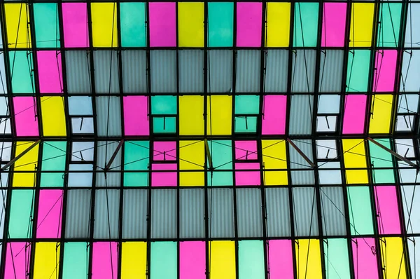 Красочная прозрачная крыша из стекла и стали, на фоне абстрактной архитектуры — стоковое фото