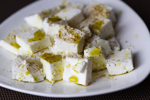 Slices of feta cheese with olive oil and spices — Stock Photo, Image