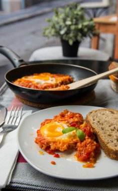 Shakshouka. Domatesli, soğanlı ve sahanda yumurtalı yumurta. Shakshouka 'nın bireysel bölümü