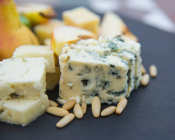 Blauschimmelkäse Und Pinienkerne Auf Dem Schwarzen Teller — Stockfoto