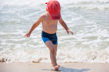 Sahilde küçük bir çocuk. Rahatlama ve sağlıklı yaşam tarzı kavramı