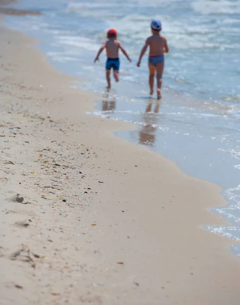 Deniz Kenarındaki Iki Çocuğun Siluetleri Bulanık Güneş Yansımalı Mavi Deniz — Stok fotoğraf